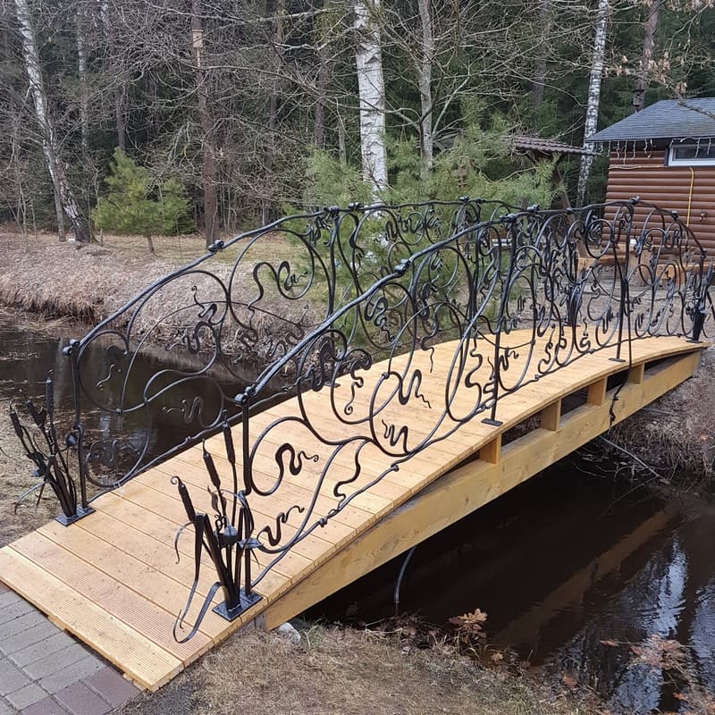 Gangbro over bekk med buede smijernsrekkverk