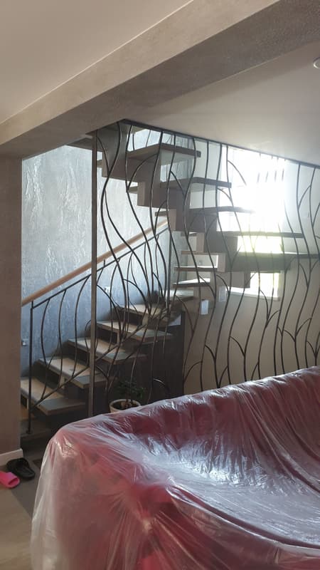 Bølgete smijernsrekkverk langs spiraltrapp